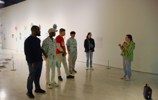 A group of 5 students with a tour guide at the Love Languages Exhibit at Art Windsor-Essex 