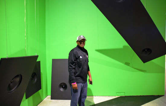 Vice-President Downtown Vikas  standing in front of a green wall at Art Windsor-Essex