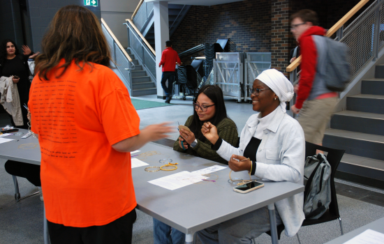 Two students making dreamcatchers in the SLC