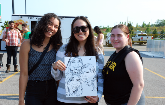 a group of 3 students posing with their caricature 