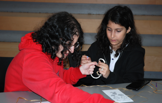 two students working together to make a dreamcatcher