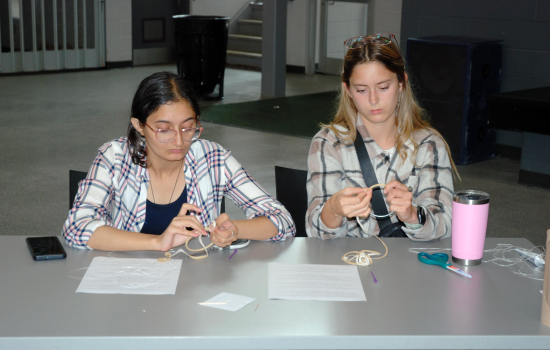 Two students making dreamcatchers in the SLC