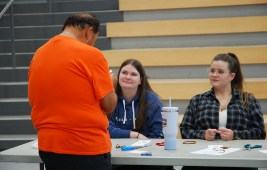 Indigenous elder showing students how to make a dreamcatcher