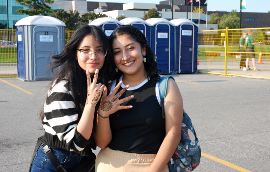 2 students showing off their fresh henna art