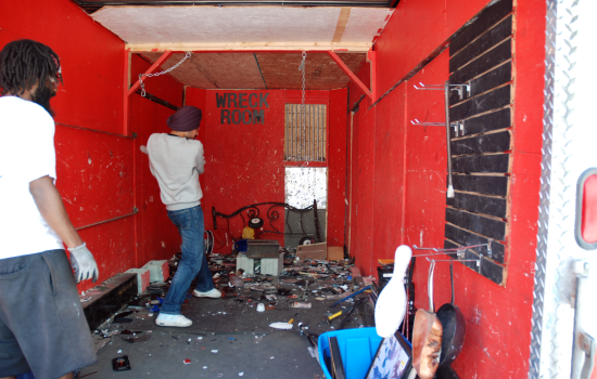 A student holding a baseball bat smashing a vhs tape hanging from a chain