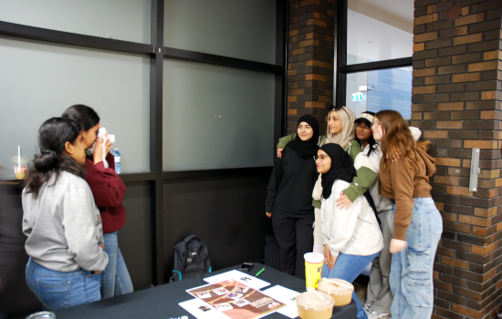 SRC VP South Harnoor taking a polaroid of a group of students