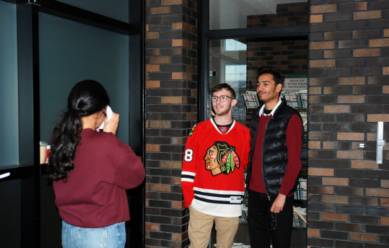 SRC VP South Harnoor taking a polaroid of two students