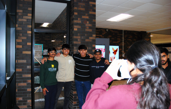 SRC VP South Harnoor taking a polaroid of a group of students