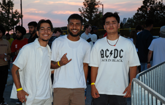 A group of 4 students at the DJ Colour Party with the sun setting in the background