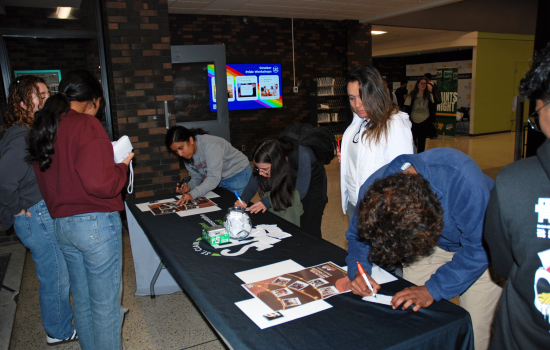 Students writing suggestions for SRC at the booth