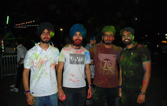 A group of 4 students covered in colour chalk