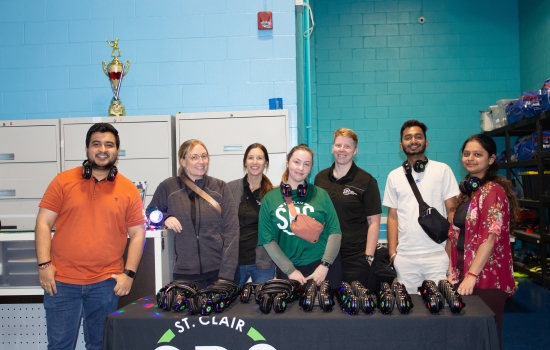 7 SRC team members with a table of headphones