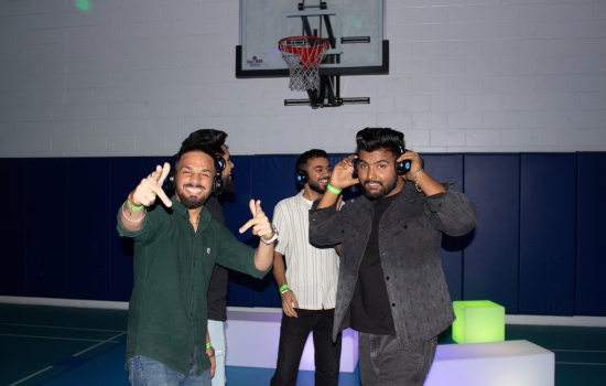 3 students dancing and smiling at the DJ Headphone Party