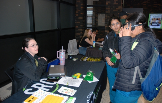 A student tries on the impairment goggles at the SRC table