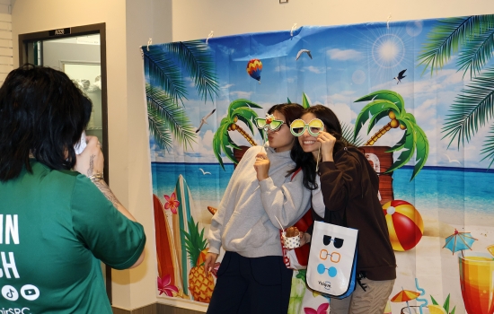 Two students pose for a polaroid